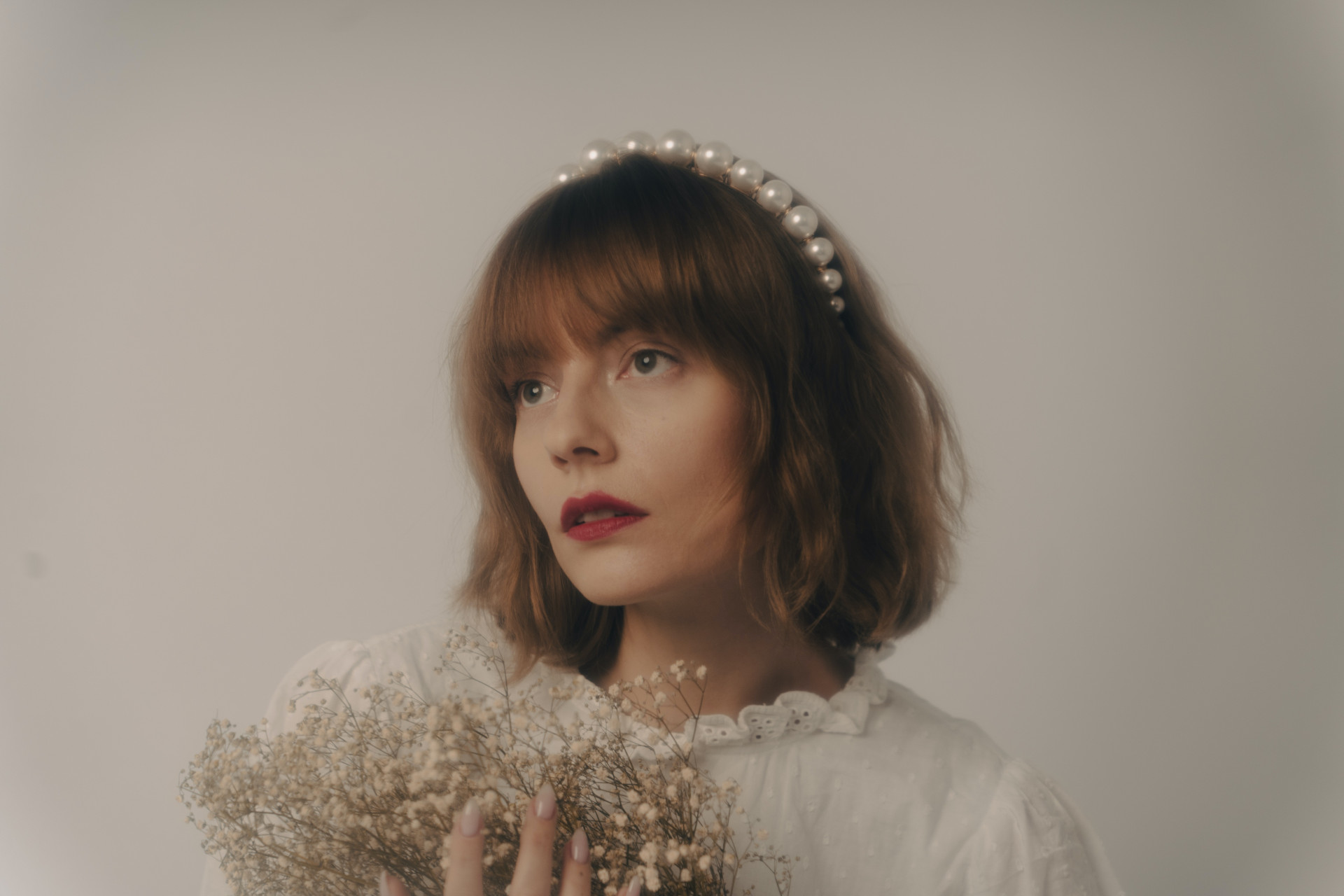 Portrait of a Woman with a Fringe, Holding a Bunch of White Flowers