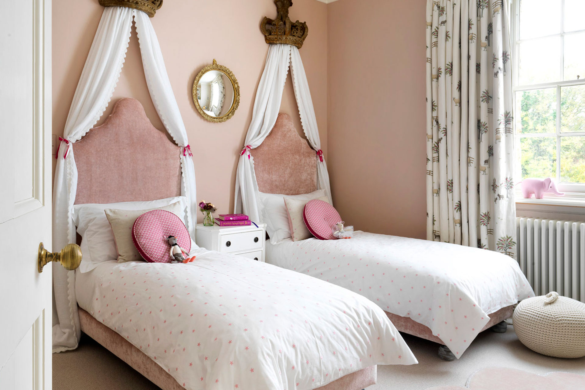a twin spare room with canopies over the beds and pink walls