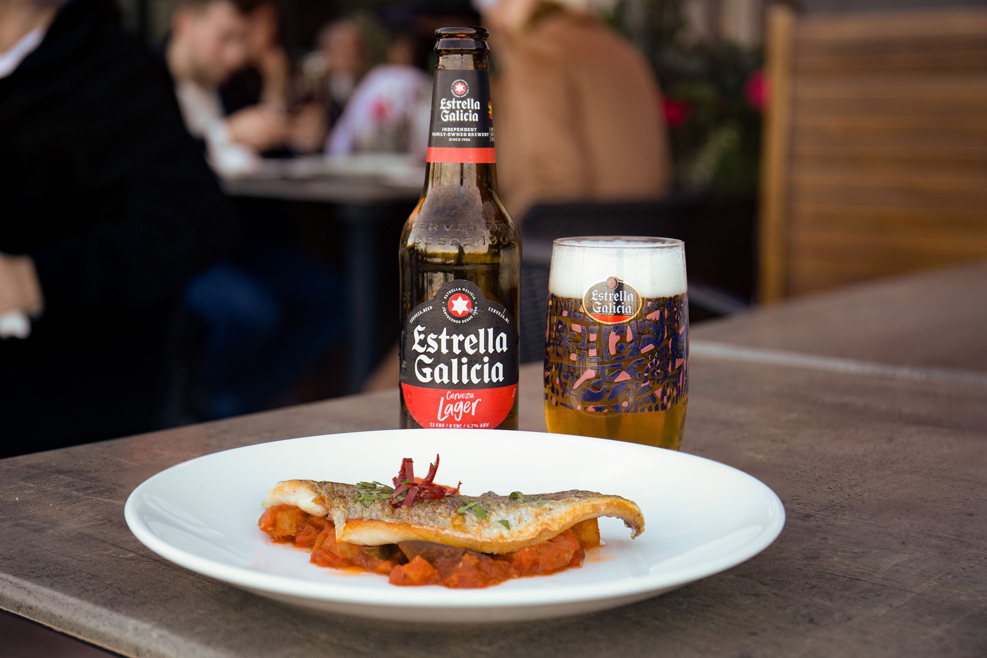 a fish dish with an Estrella Galicia beer