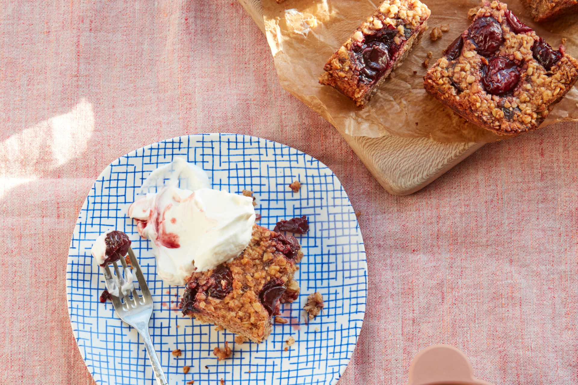 Cherry bakewell flapjacks served with ice cream on a blue plate