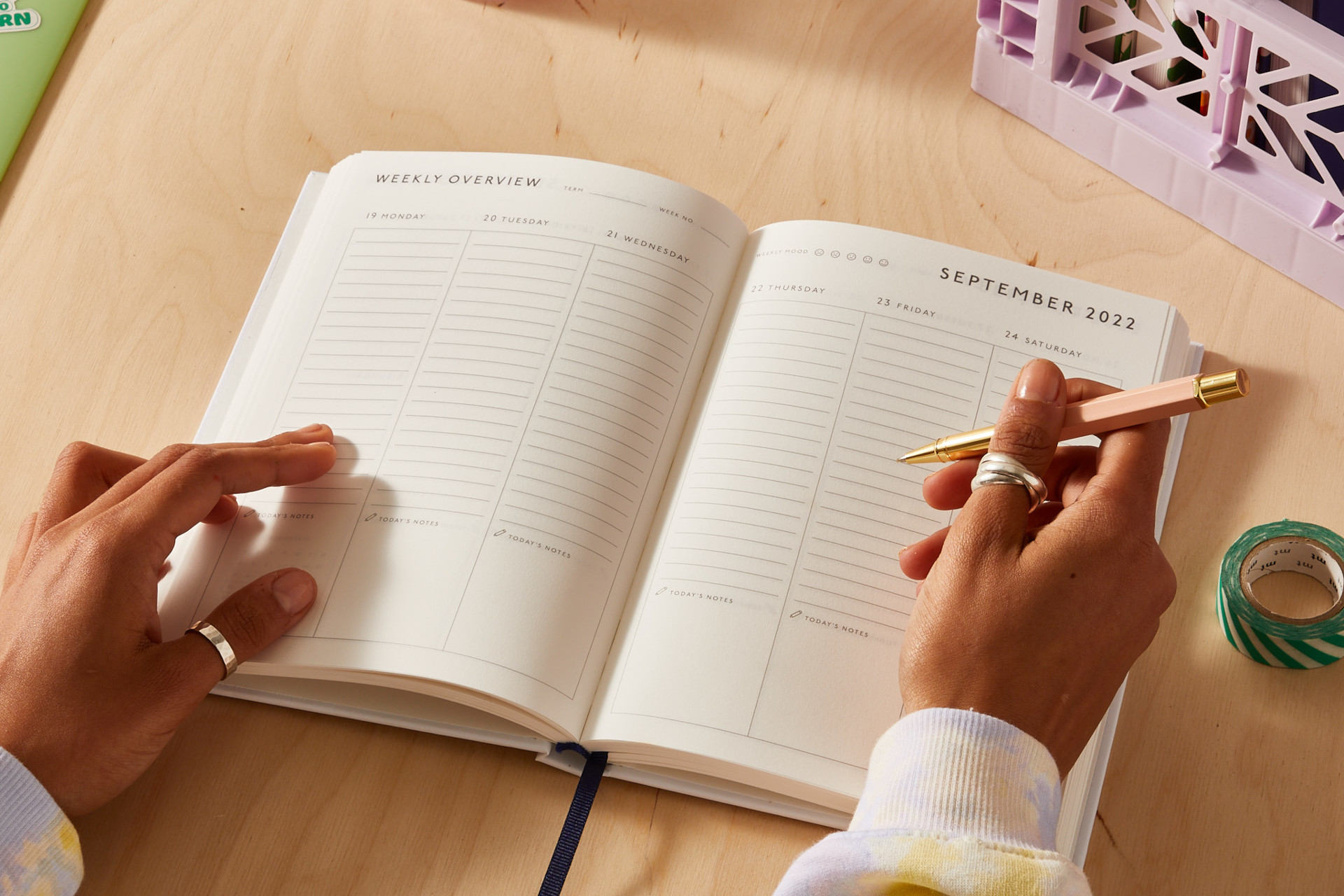 Close up of someone writing in a diary at a desk