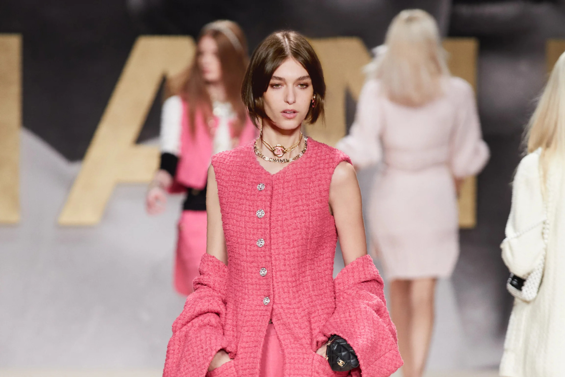 Close up if model in pink vest and shorts walking down the runway