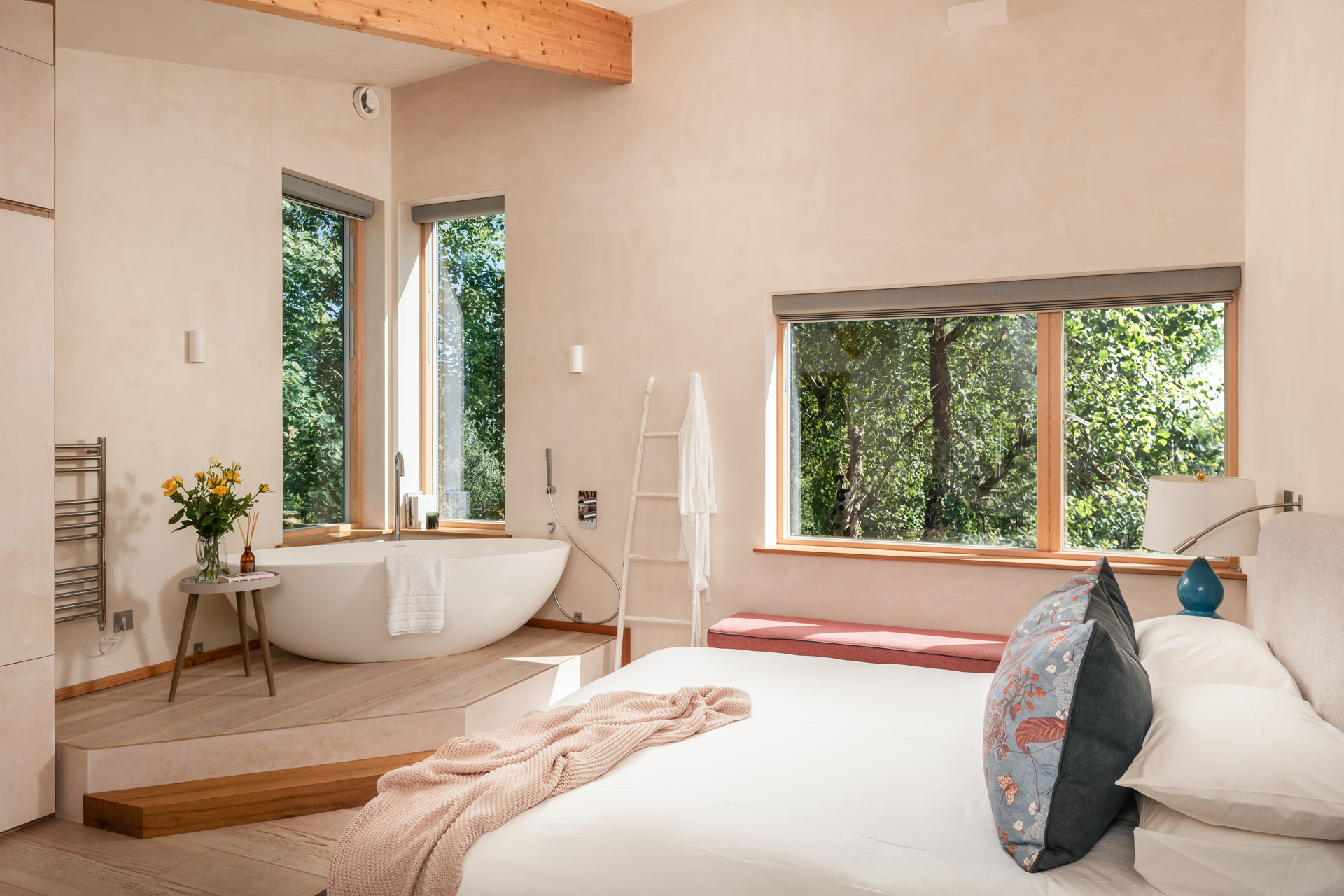 a light pink bedroom with freestanding bath