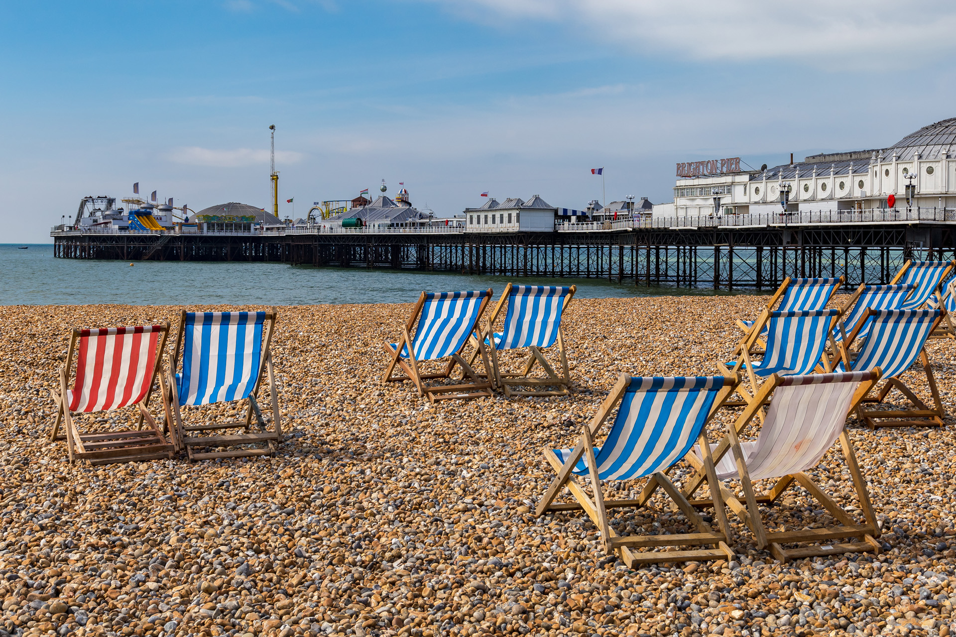 Brighton Beach with deck chairs and Brighton Palace Pier, Brighton, East Sussex, England, UK