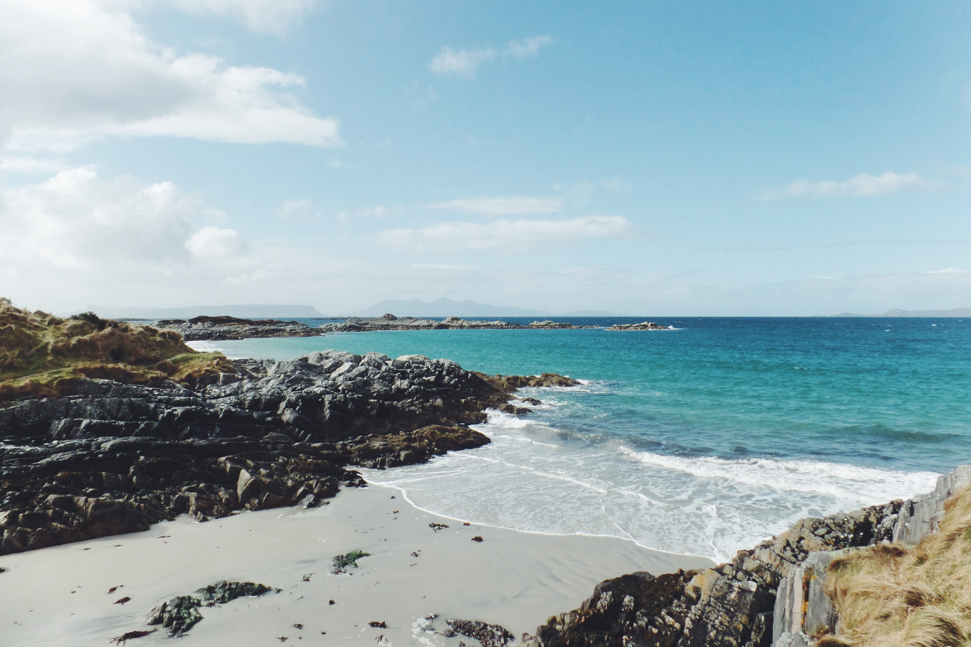 black rocks leading to crystal blue sea water