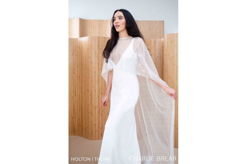 Model wearing white dress and glittery cape