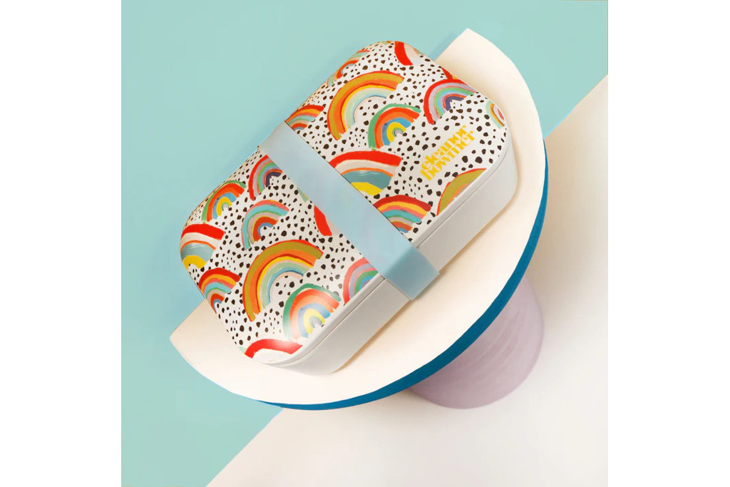 Colourful lunchbox on wooden stand against blue background
