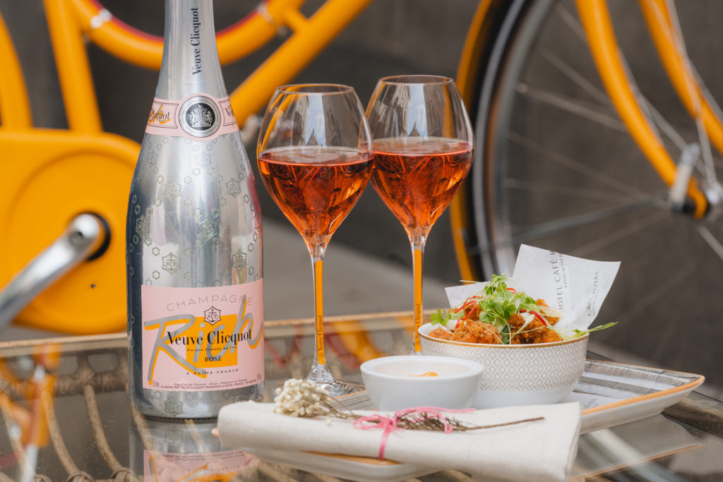 a bottle of veuve cliquot champagne with two glasses and a small plate