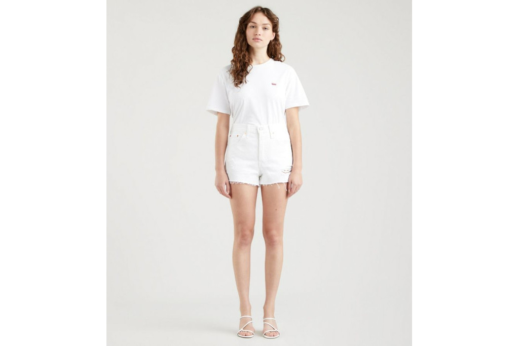 Woman stood in white top, shorts and strappy heels