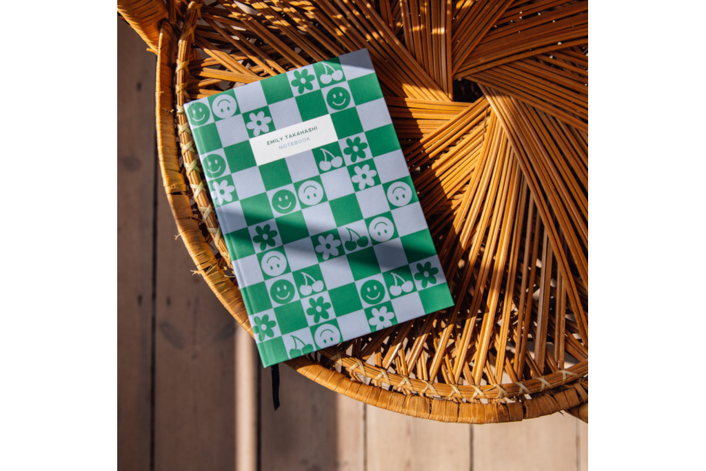 Blue and green check notebook on woven table