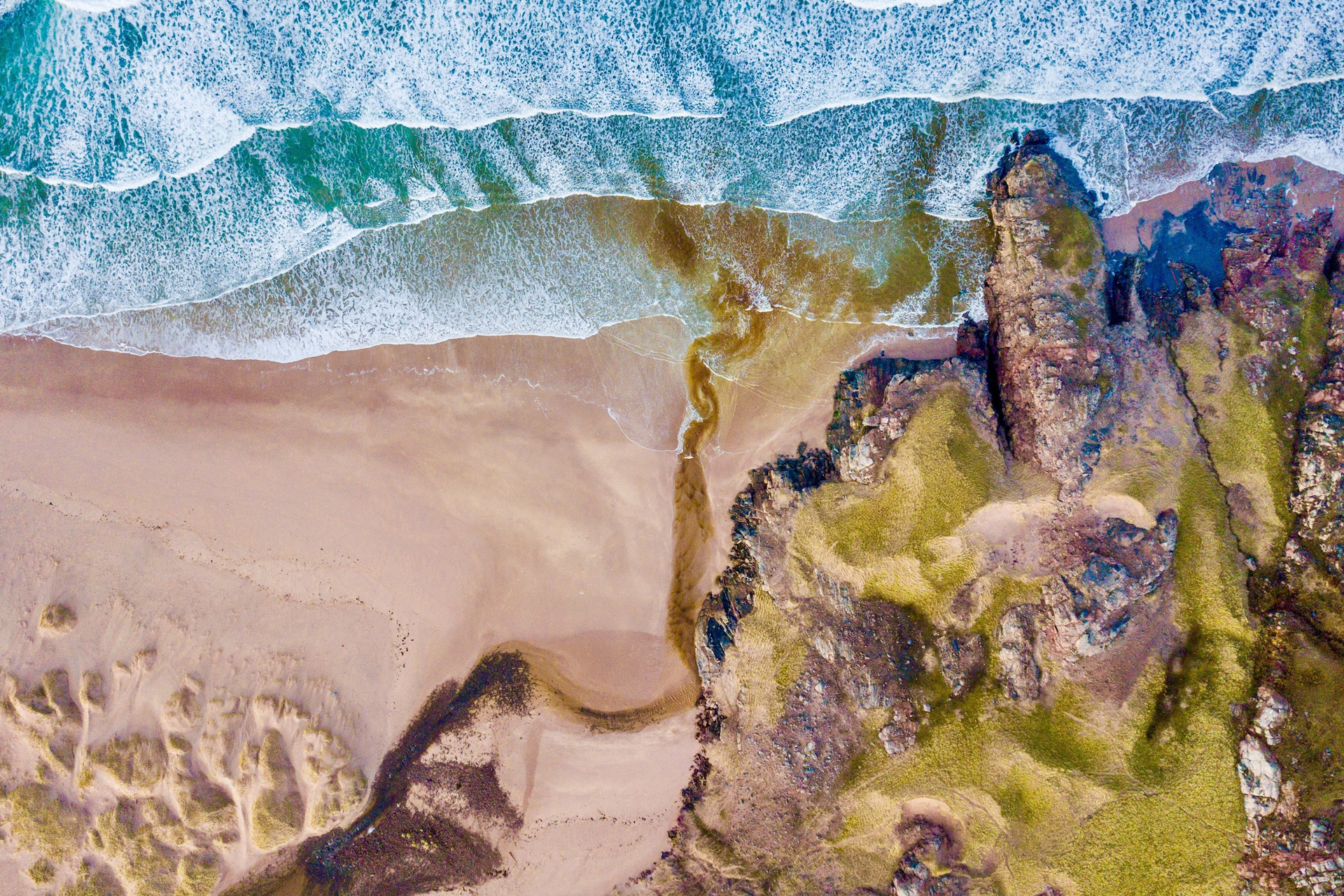 sea washing onto shore with rocks and algae