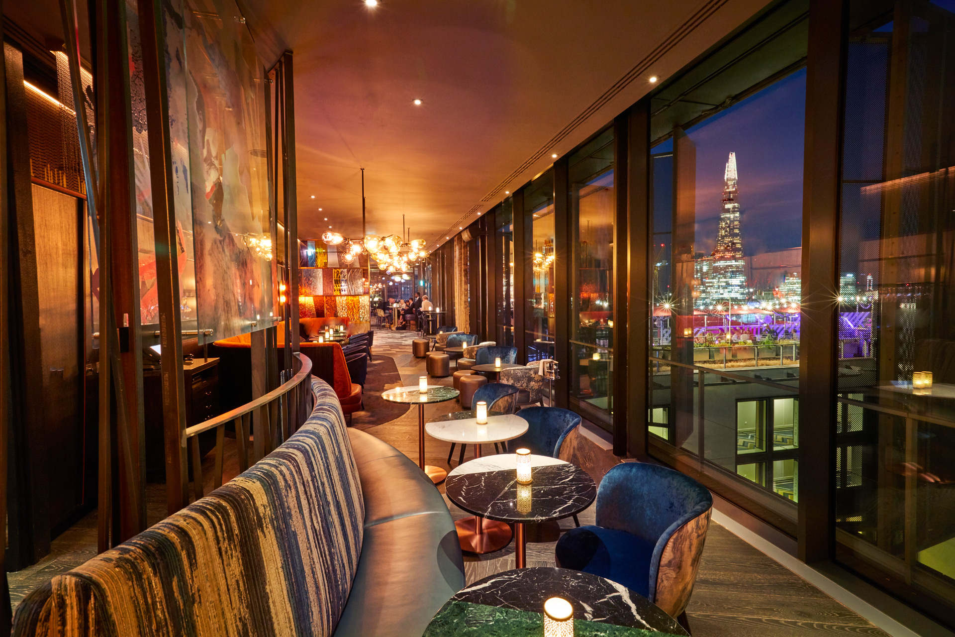 Rooftop bar at night with views over London.