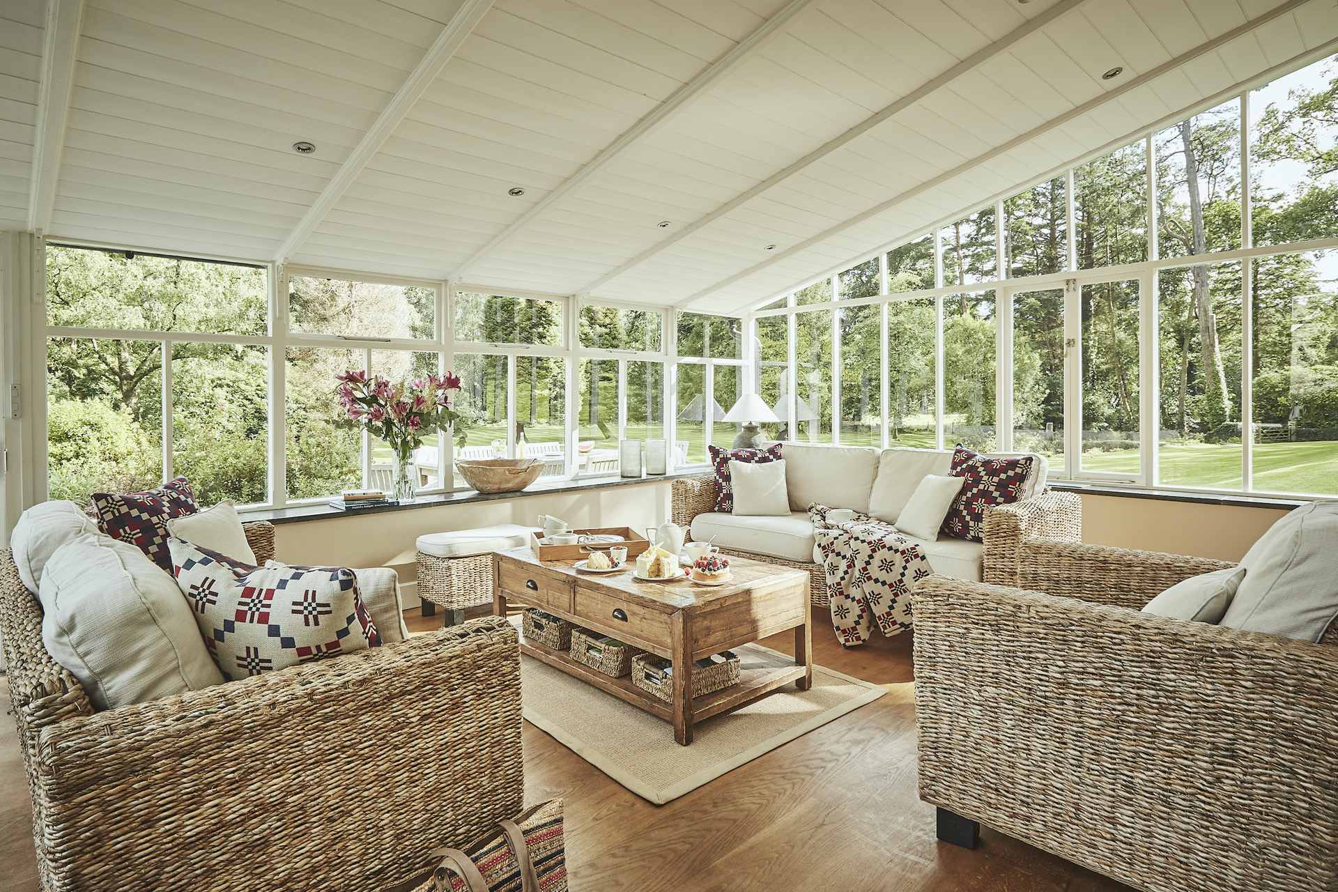 tan llan conservatory with chairs around a central coffee table