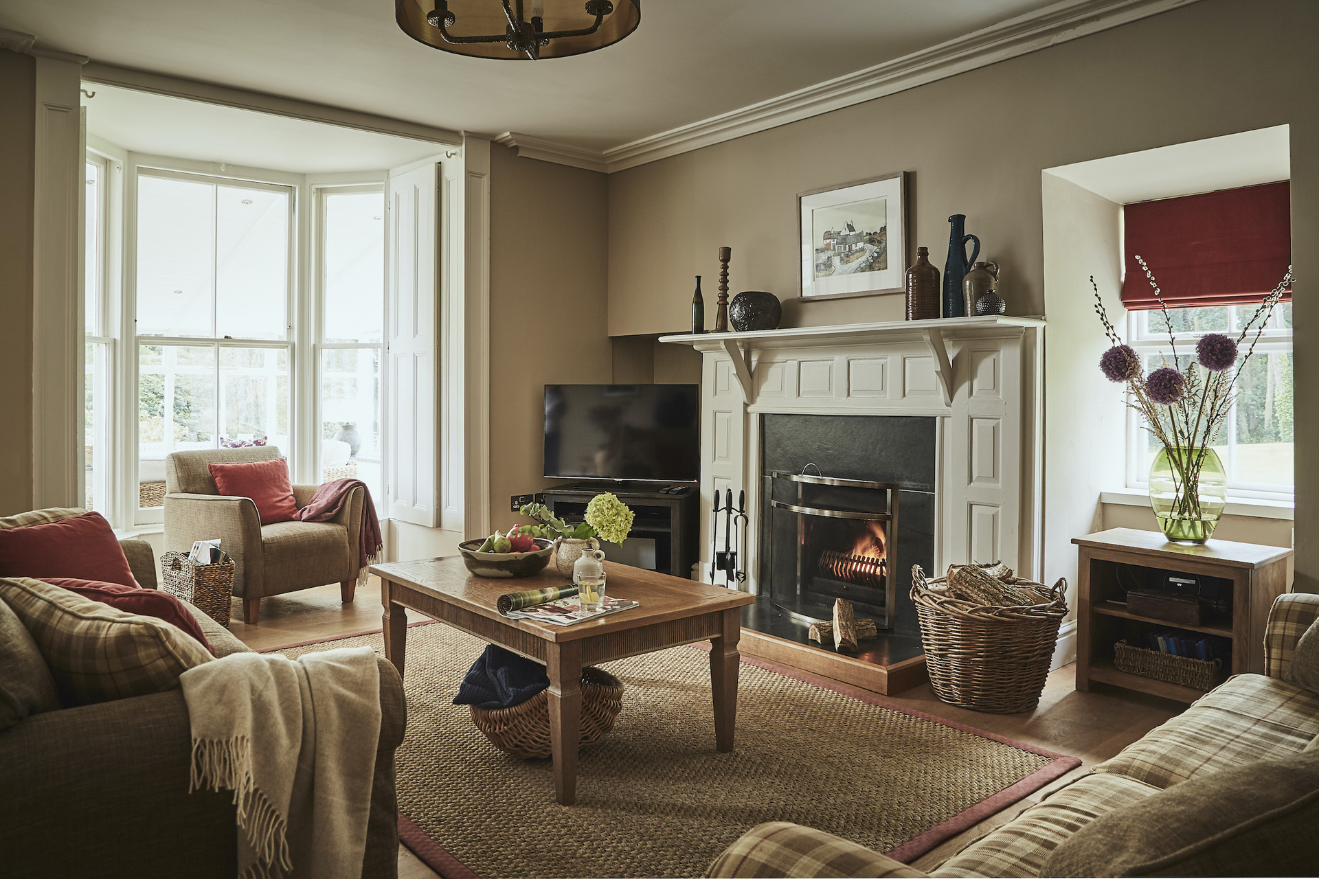 a living room area with sofas, arm chairs and fire place