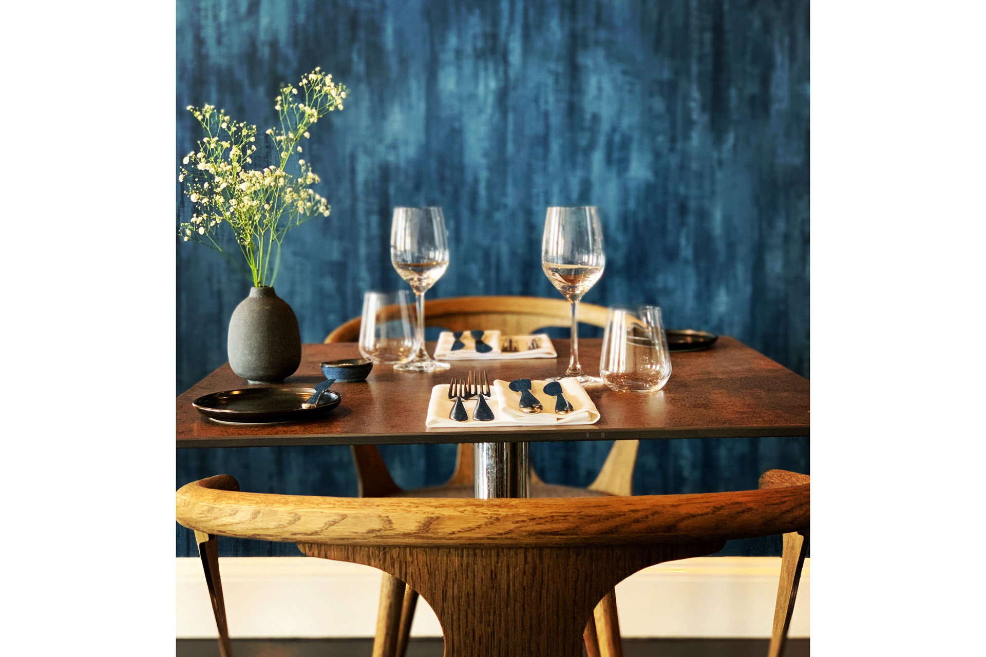 Blue wall behind table set for dinner