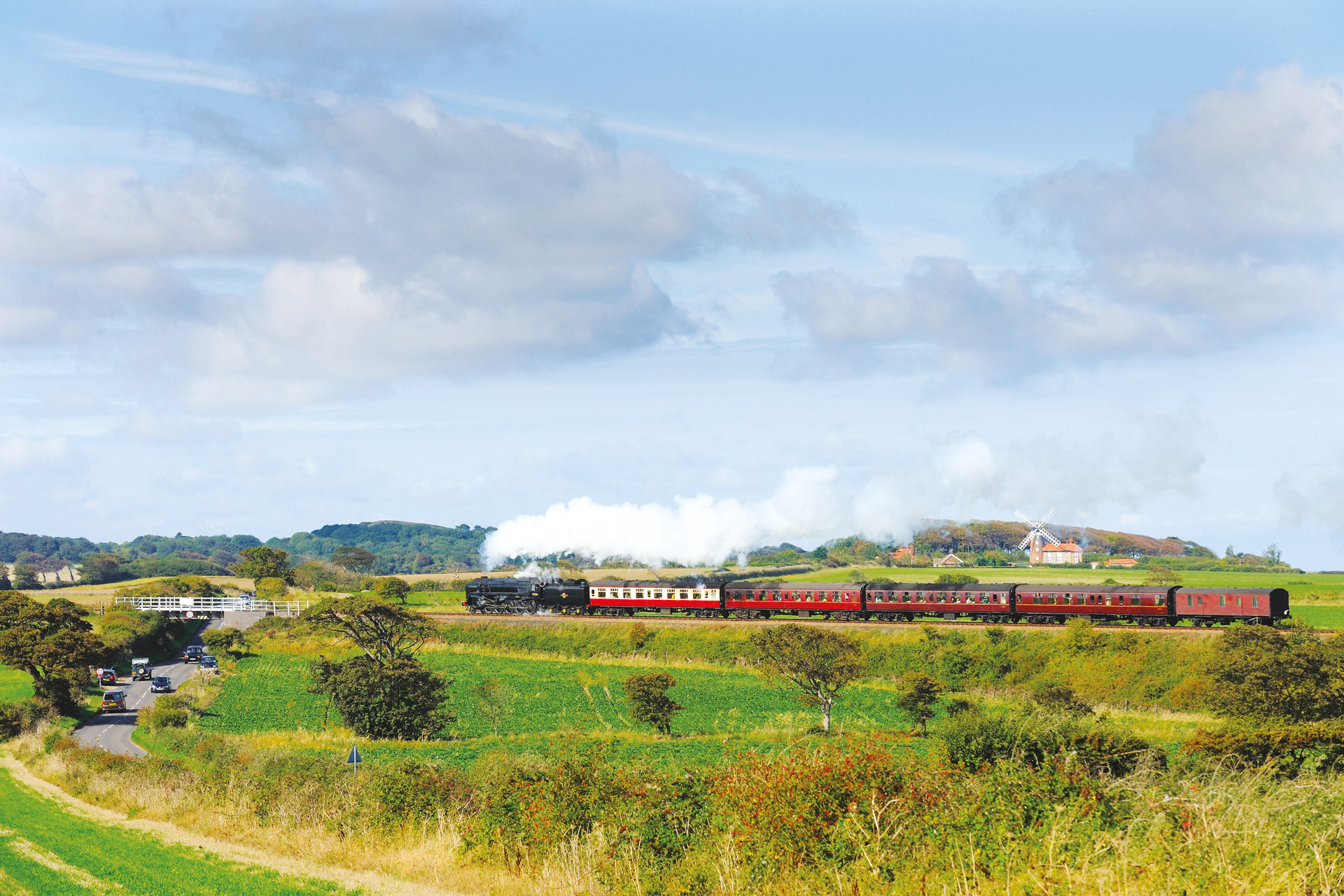 CRNKWA 'Black Prince', a steam locomotive travelling past Weybourne windmill on the North Norfolk Railway (NNR), also known as the 'Poppy Line'