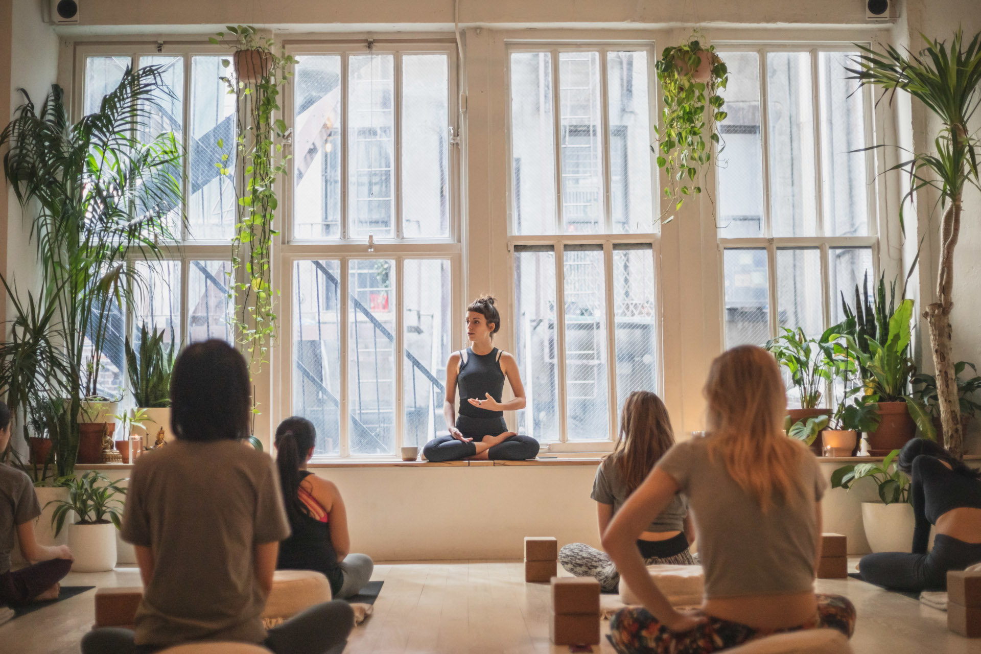 Yoga class in a light studio with large windows