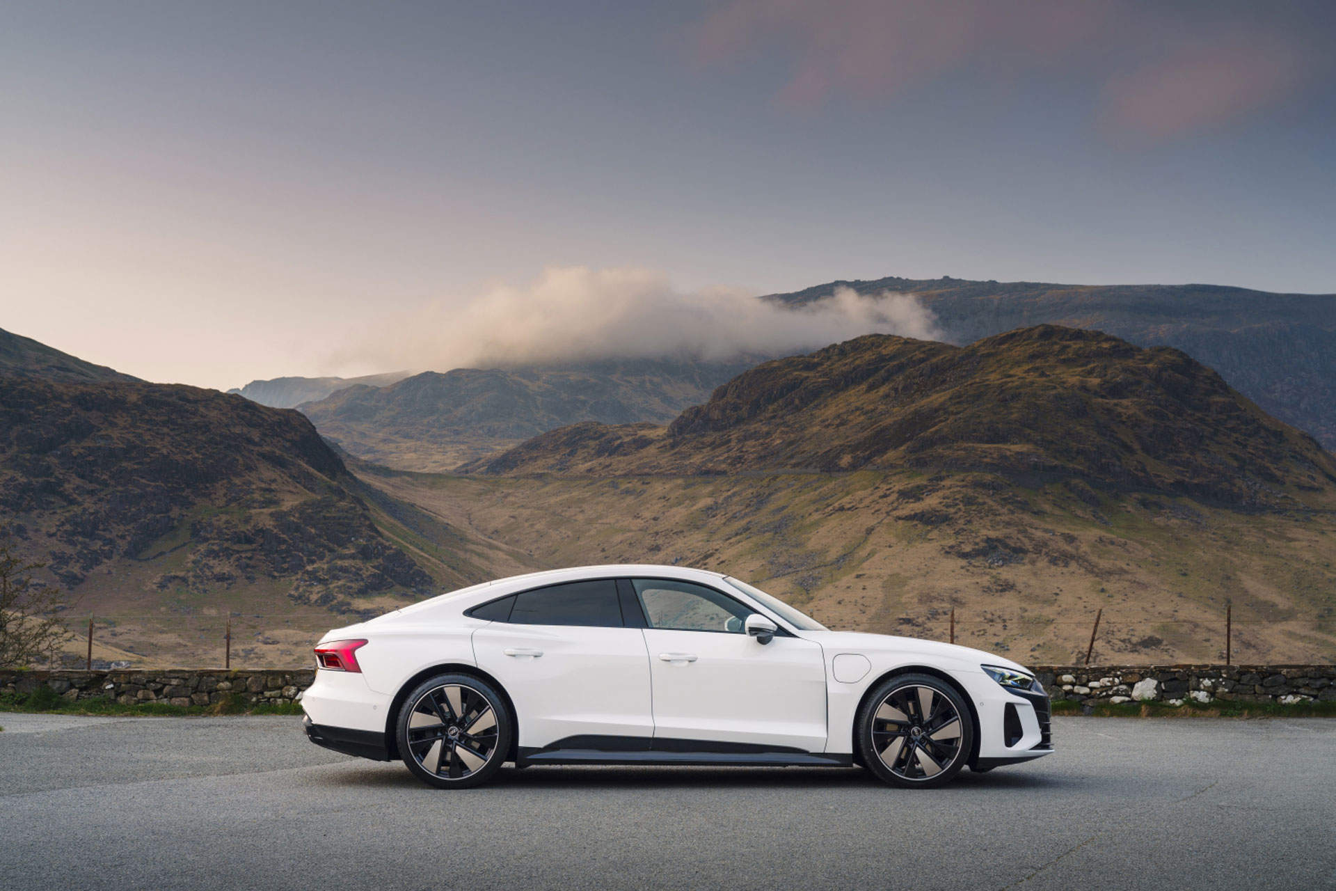 a side view of the Audi e-tron GT with a mountainous landscape behind