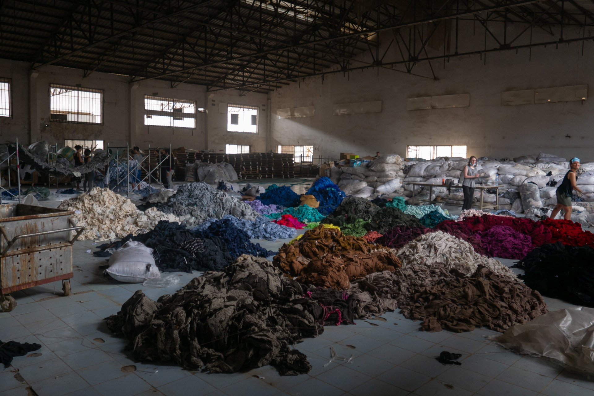 Warehouse with large piles of clothes on the floor