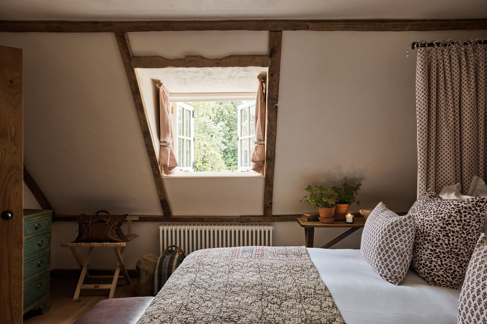 A double room and angled wooden beamed historic ceilings feature at The Fox at Oddington Hotel