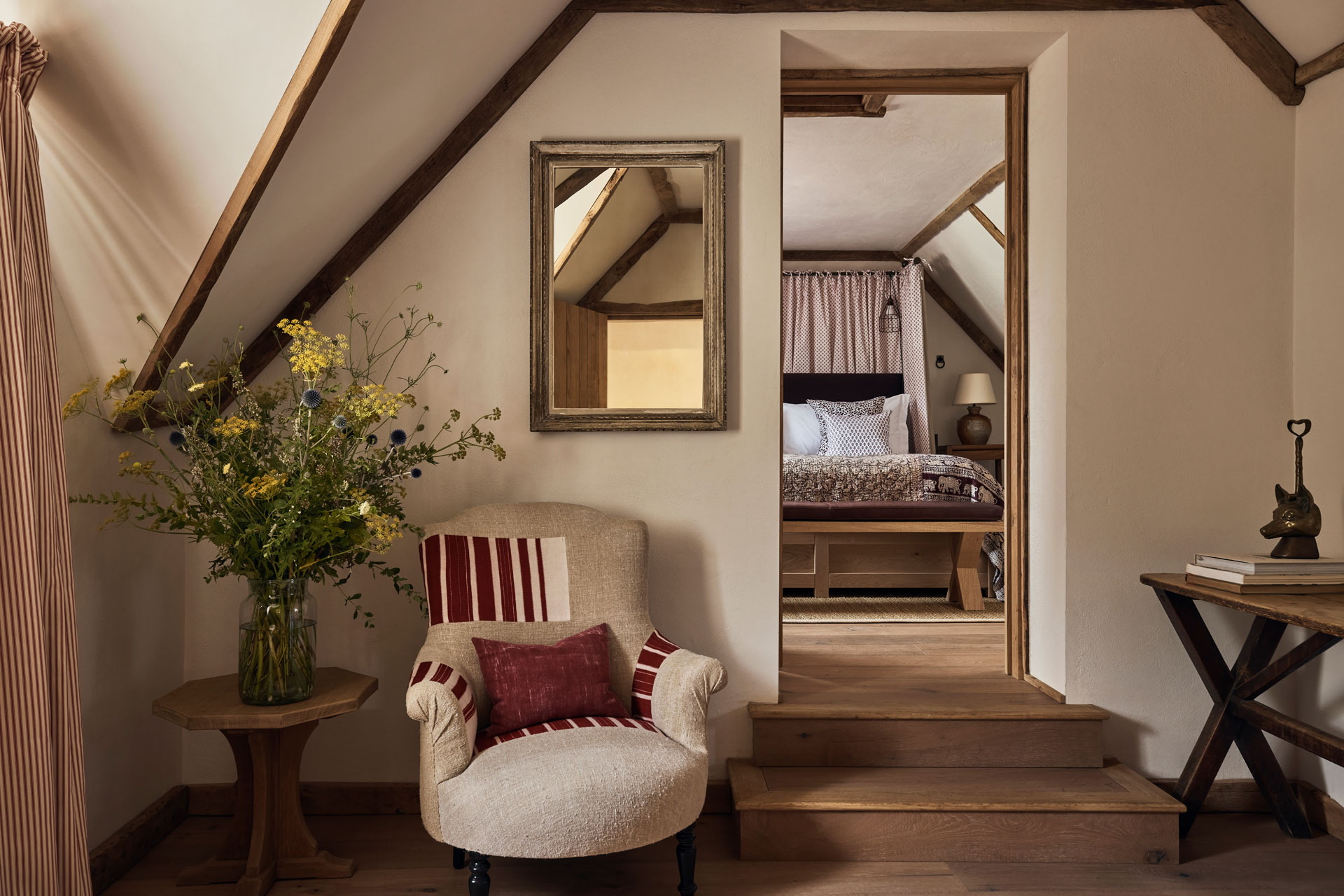The Hedgerow Room at the Cotswold pub hotel, featuring wooden beamed ceilings and soft armchairs