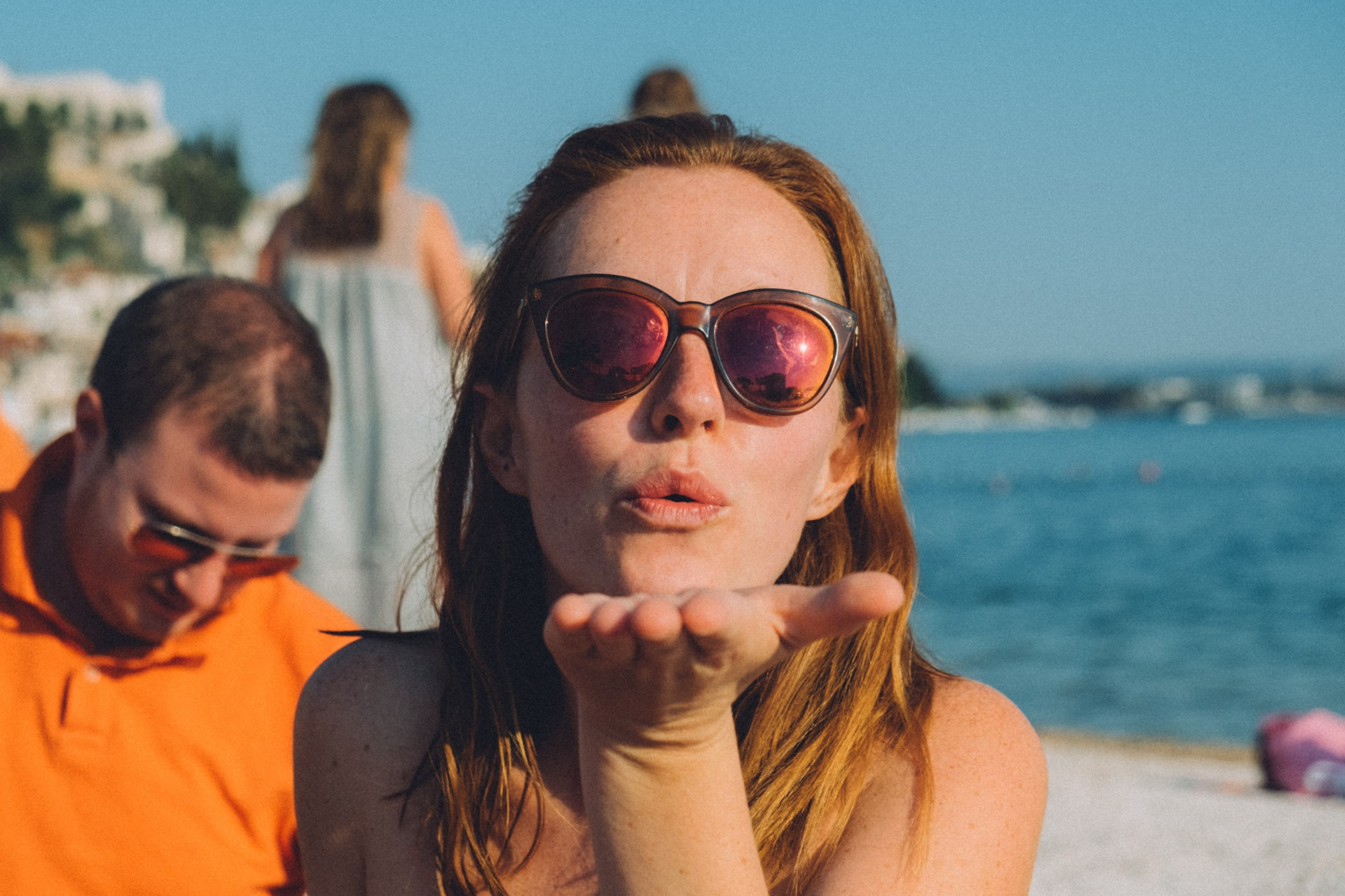 Woman on the beach blowing a kiss to the camera