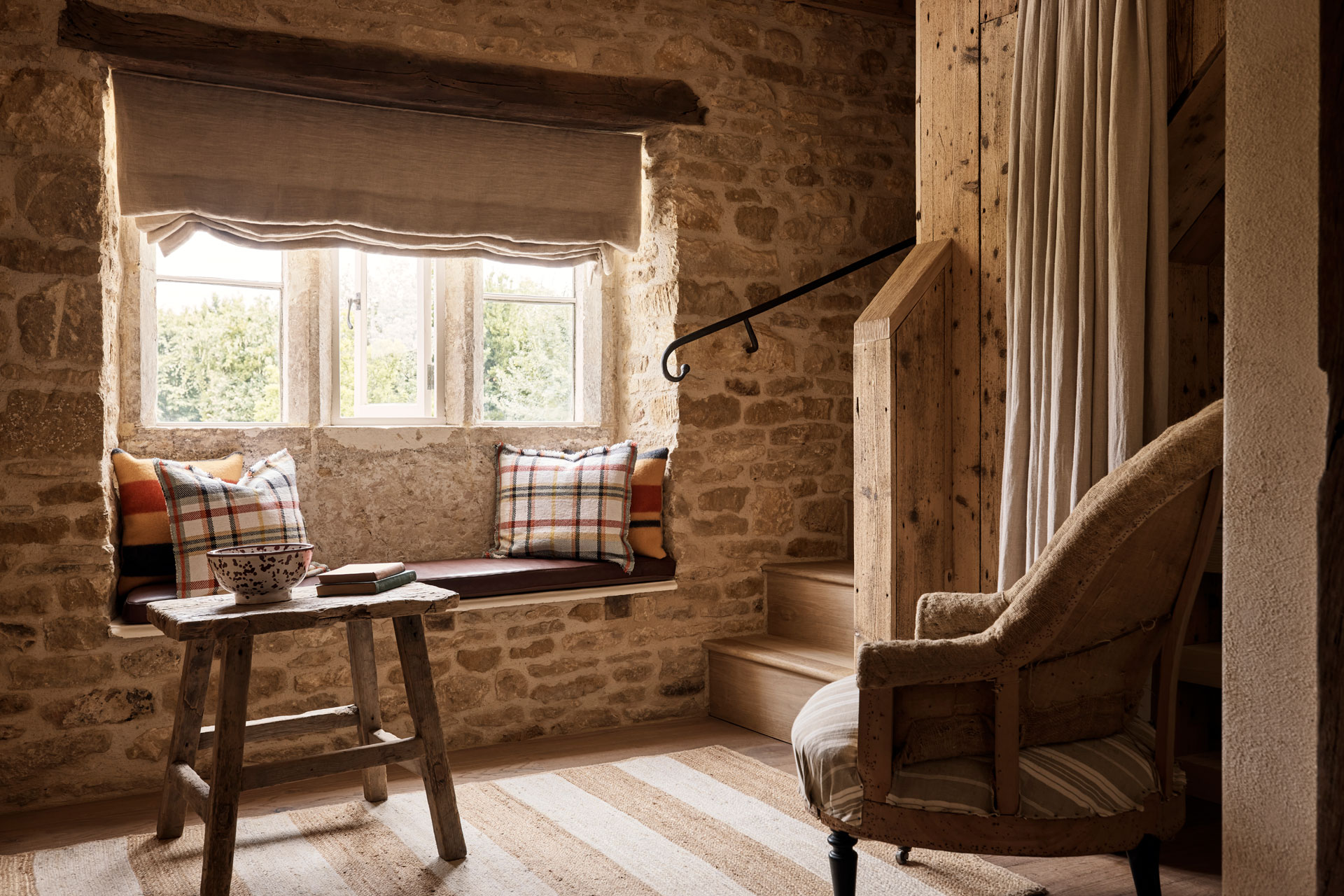 The Huntsman room, featuring an exposed stone wall, an arm chair and small table.