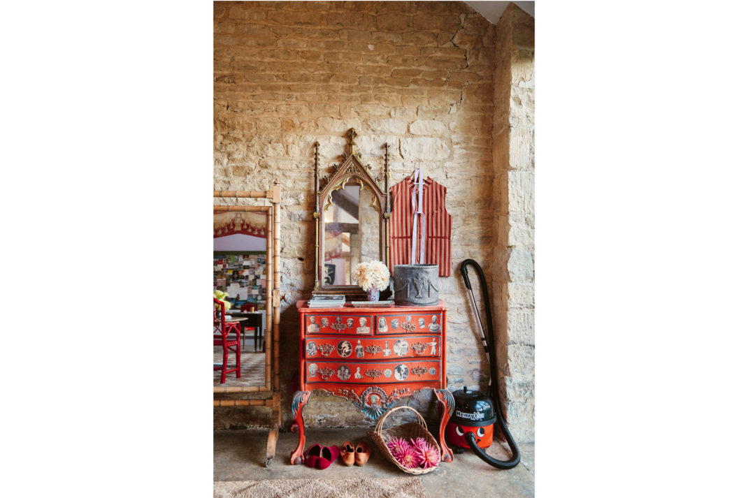 Henry the Hoover stands next to a gothic revival mirror behind a pointed exposed stone wall at the home of Luke Edward Hall