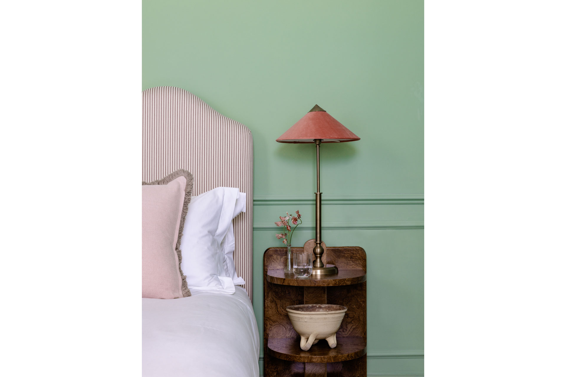 a light green pea coloured wall and a pink headboard feature in a bedroom at Kin House