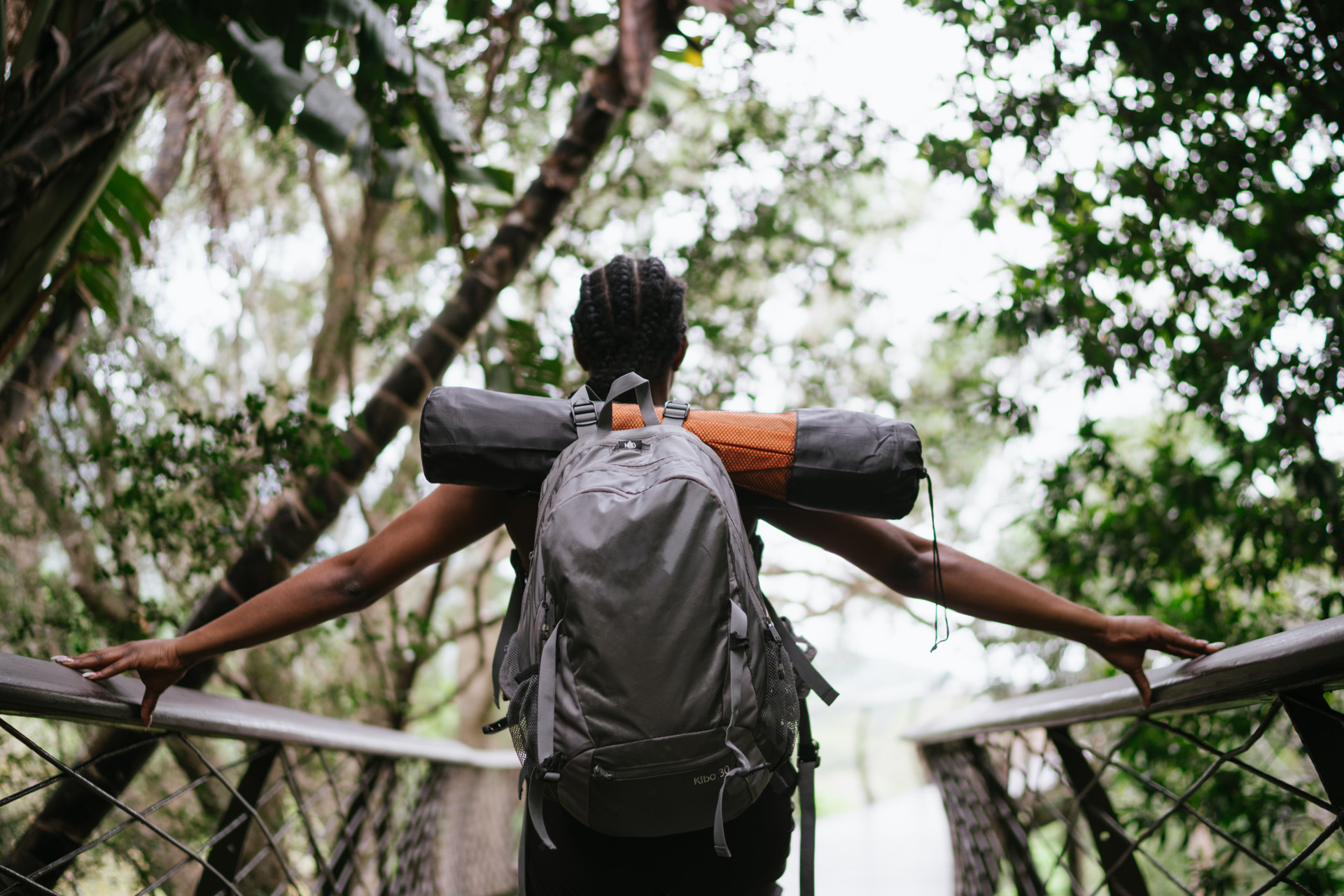 a girl with a backpack walking in the wilderness