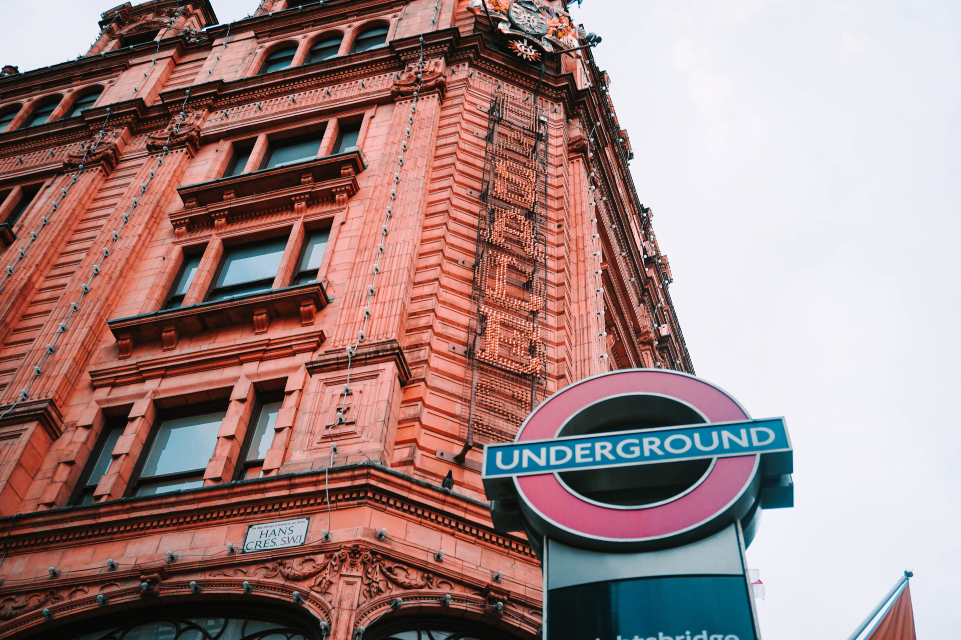 Looking up at Harrods with the London Underground sign in the foreground