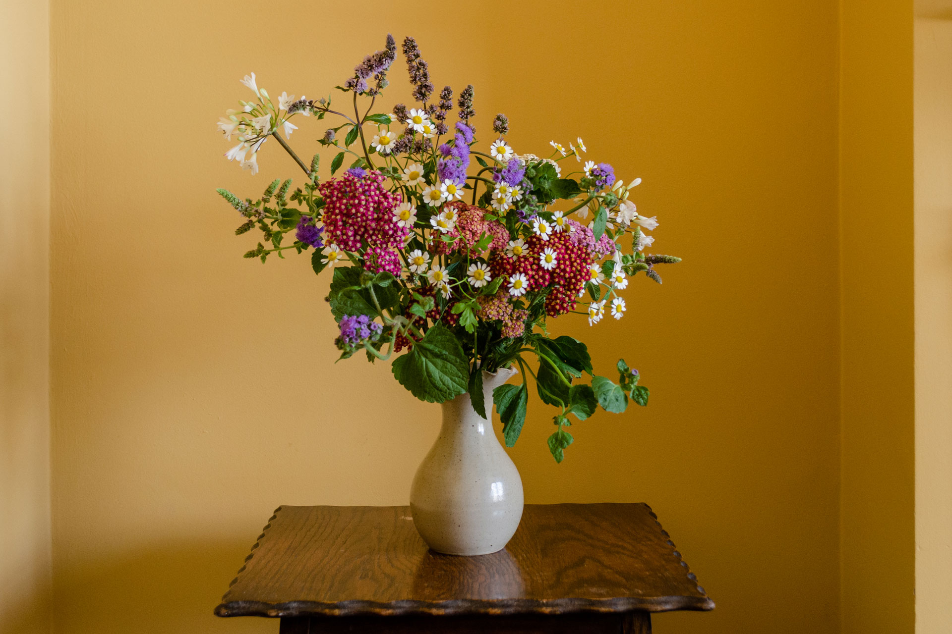 a bouquet of wild flowers in a vase by Uncut Stems