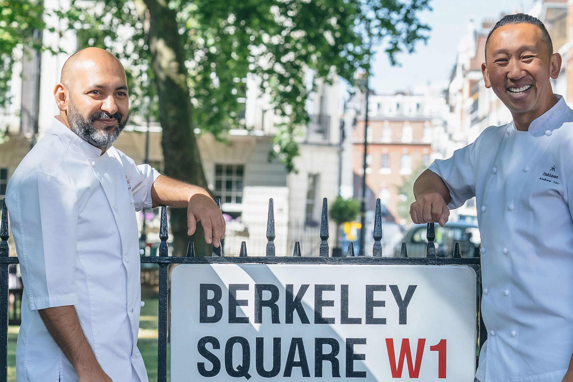 Two chefs standing by street sign