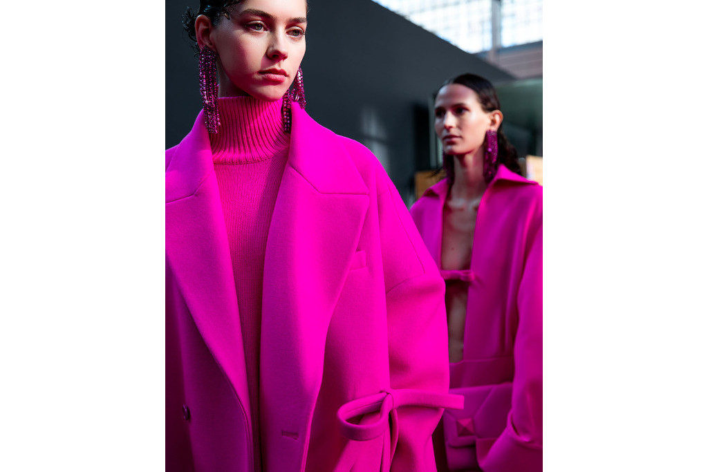 Models in pink outfits getting ready for the runway