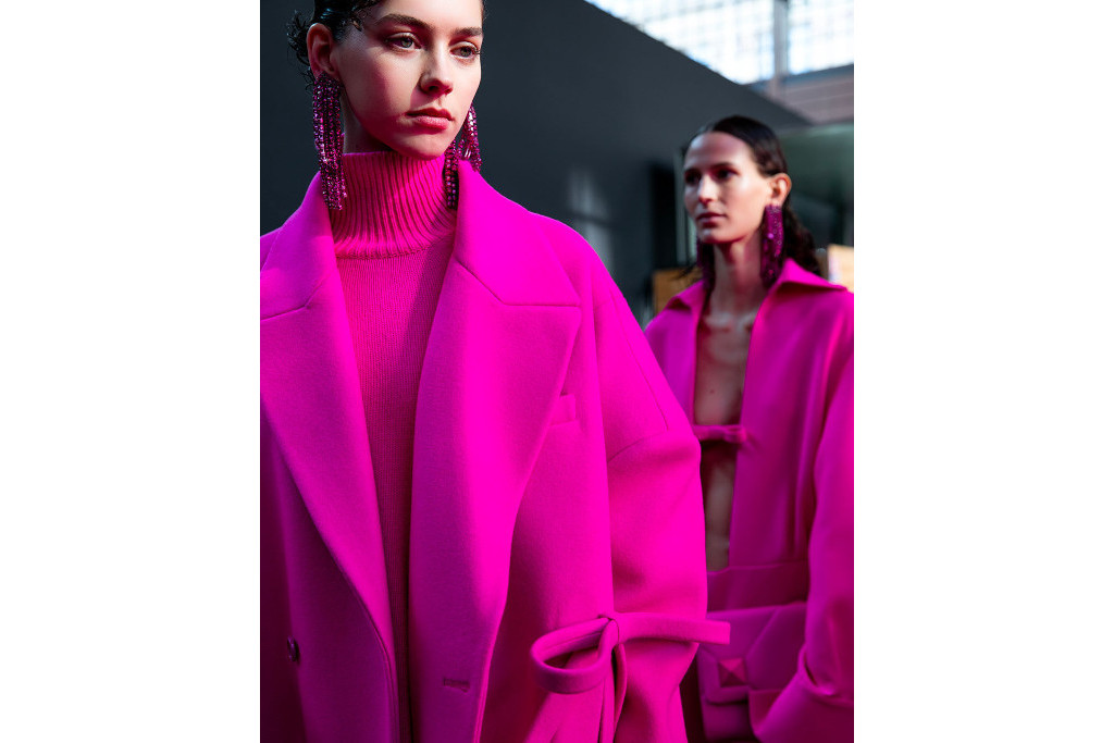 Models in pink outfits getting ready for the runway