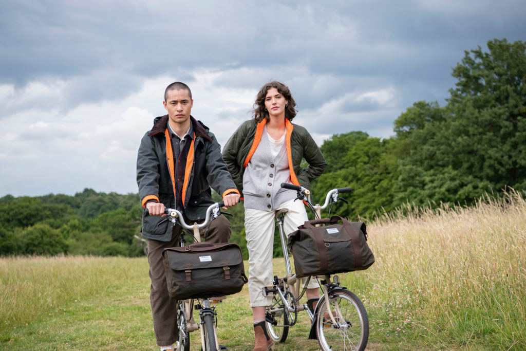 Models sat on bikes in a field