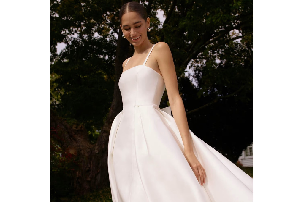 Model stood in white dress outdoors