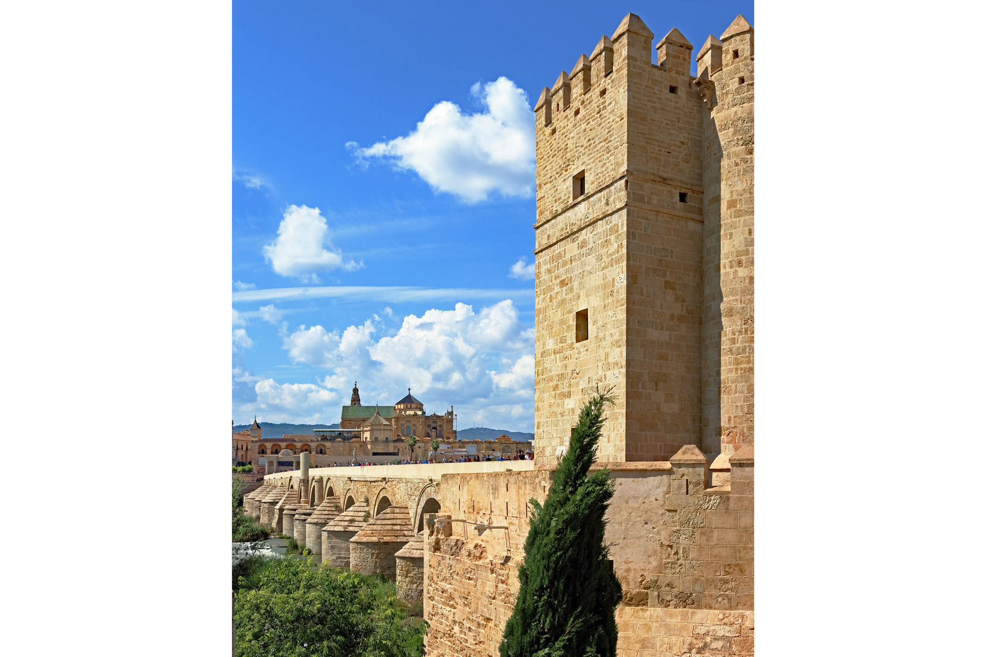 Sunny day in Cordoba may with a crowd walking over the Puente romano between the Mesquita and the Torre de la Calahorra