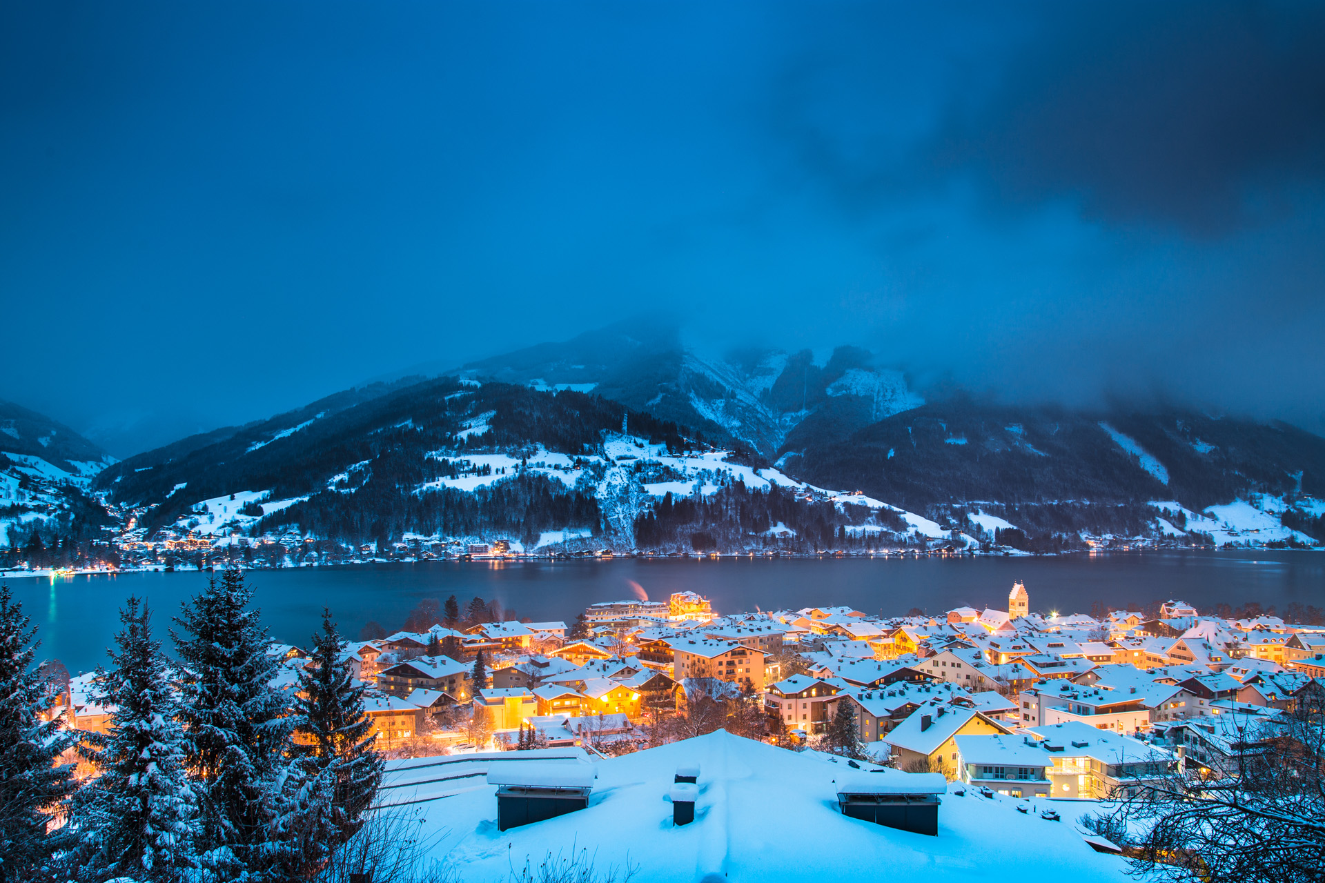 Panoramic view of Zell am See with Zeller See lake in twilight during blue hour at dusk in winter, Salzburger Land, Austria