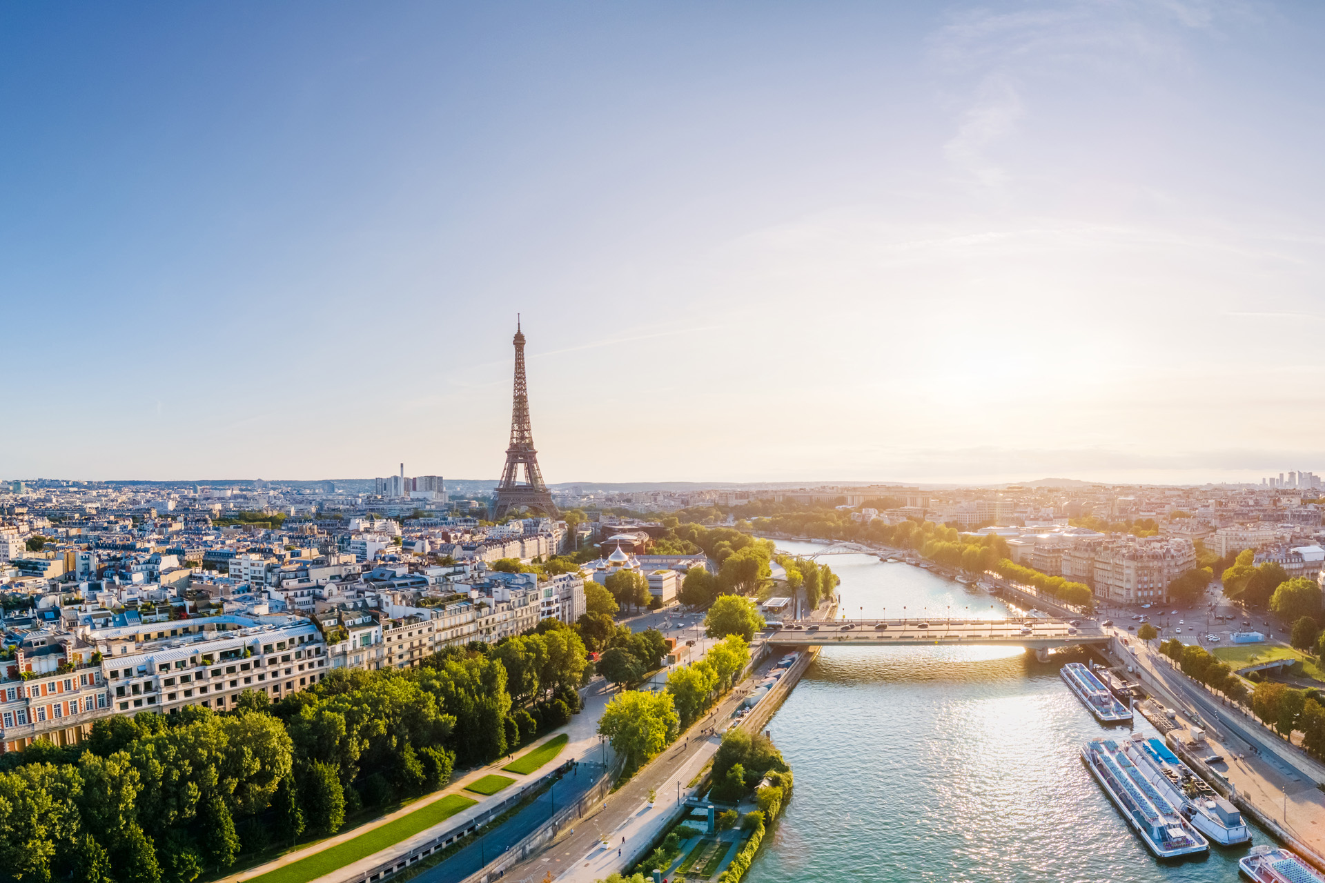 Paris aerial panorama with river Seine and Eiffel tower, France. Romantic summer holidays vacation destination. Panoramic view above historical Parisian buildings and landmarks with blue sky and sun