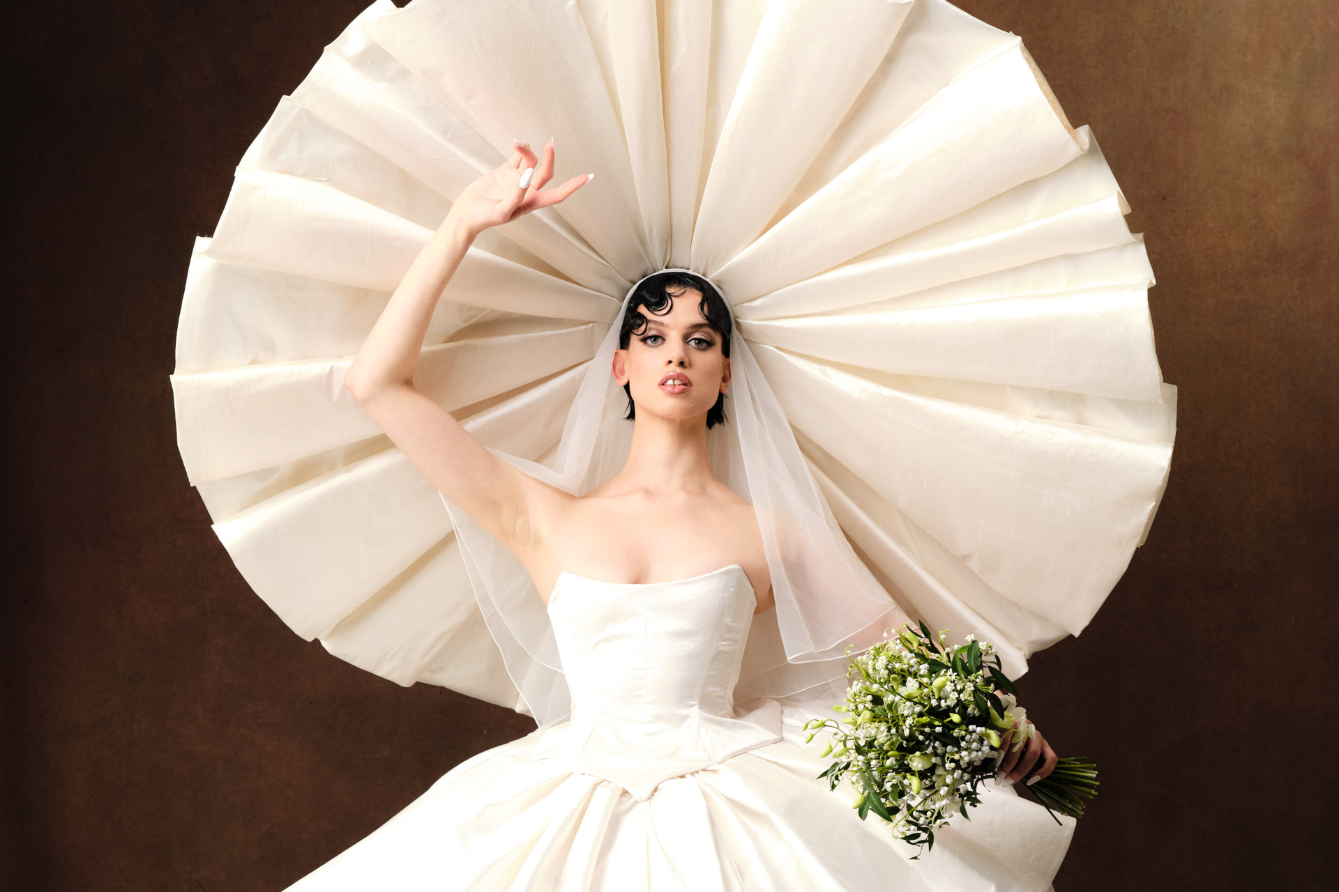 Model wearing white ballerina outfit and large white headpiece