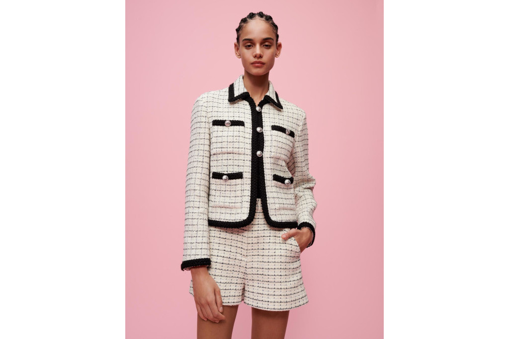 Model in white tweed jacket and shorts