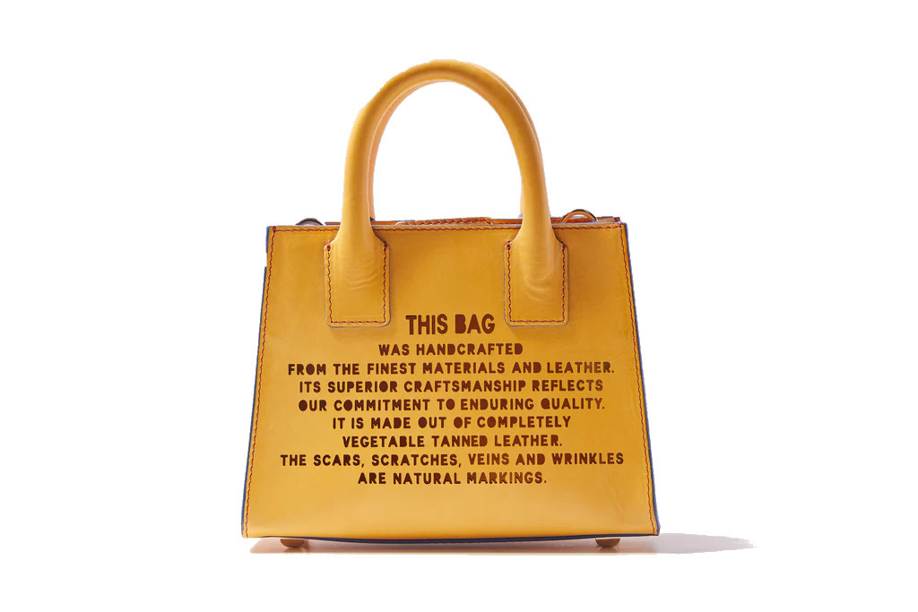 Yellow leather tote with text on the front
