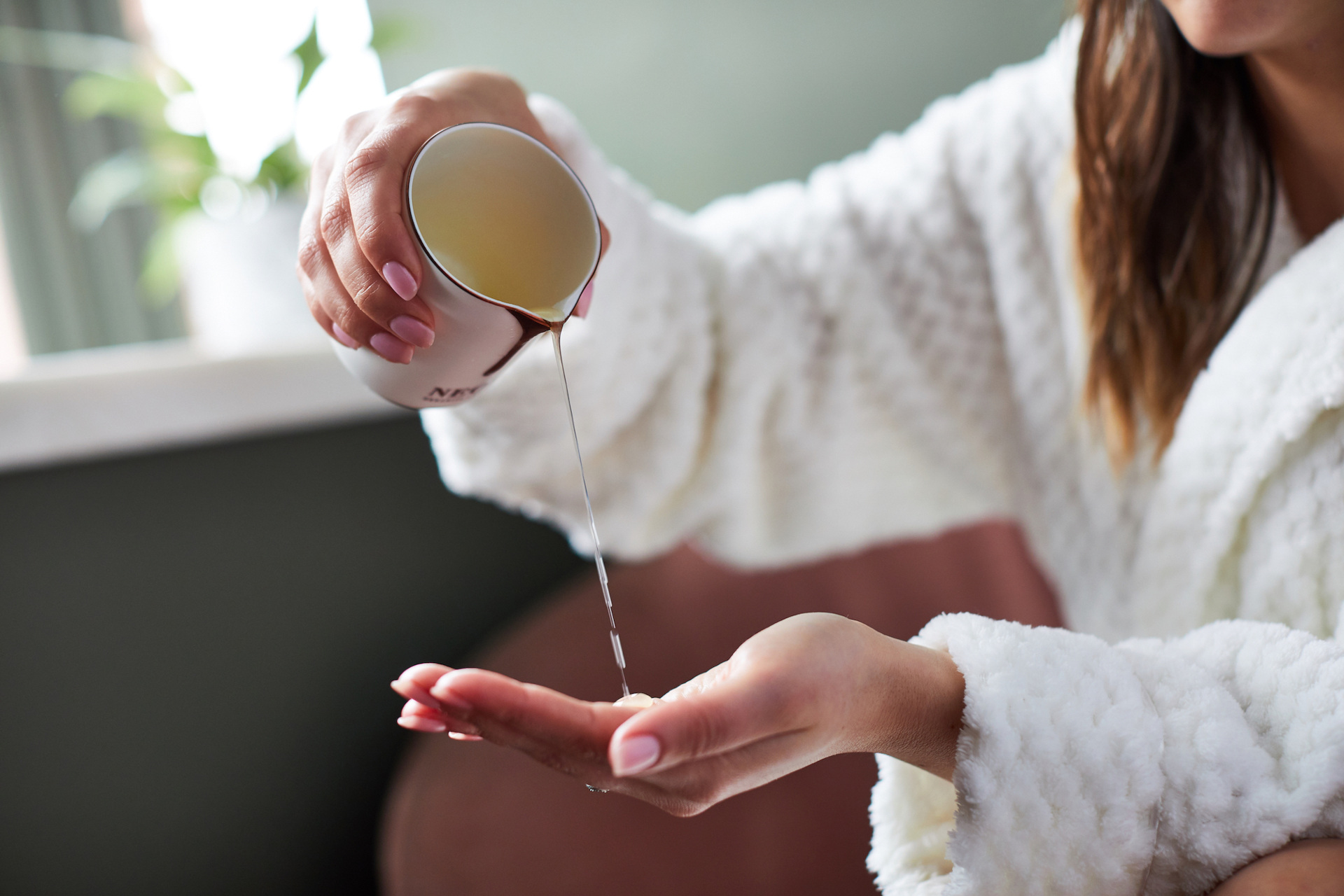 Woman pouring candle wax into hand