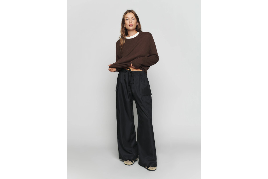 Model in black cargo trousers and burgundy jumper