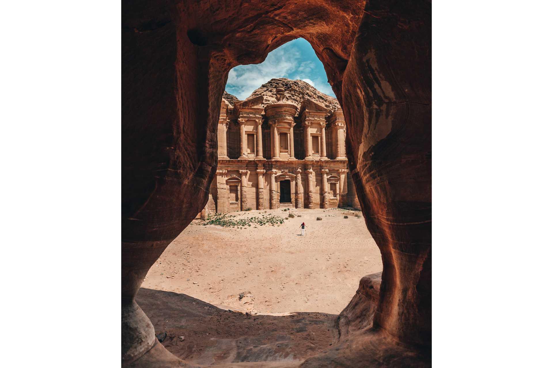 a beige building seen through a curvy rock