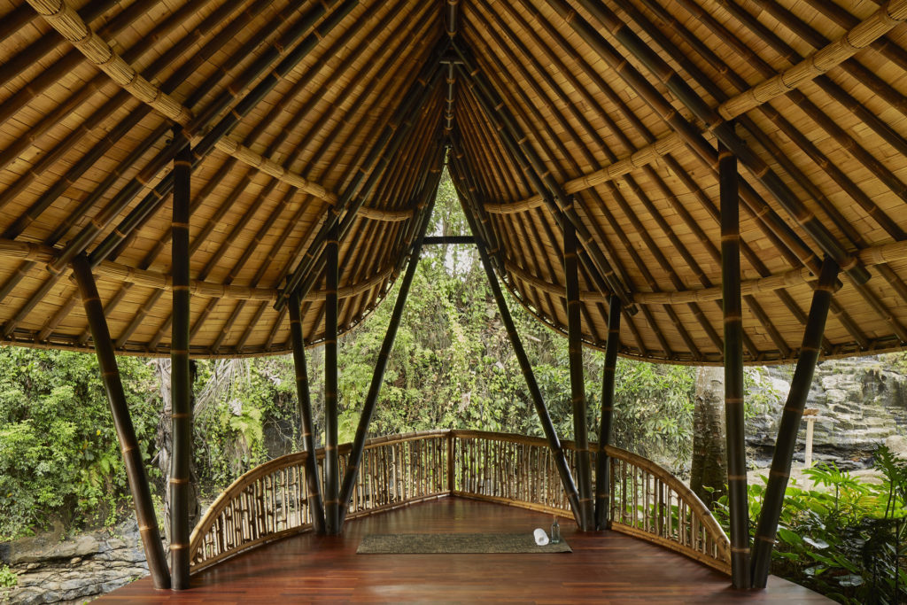 a yoga stage with wood roof overlooking forest