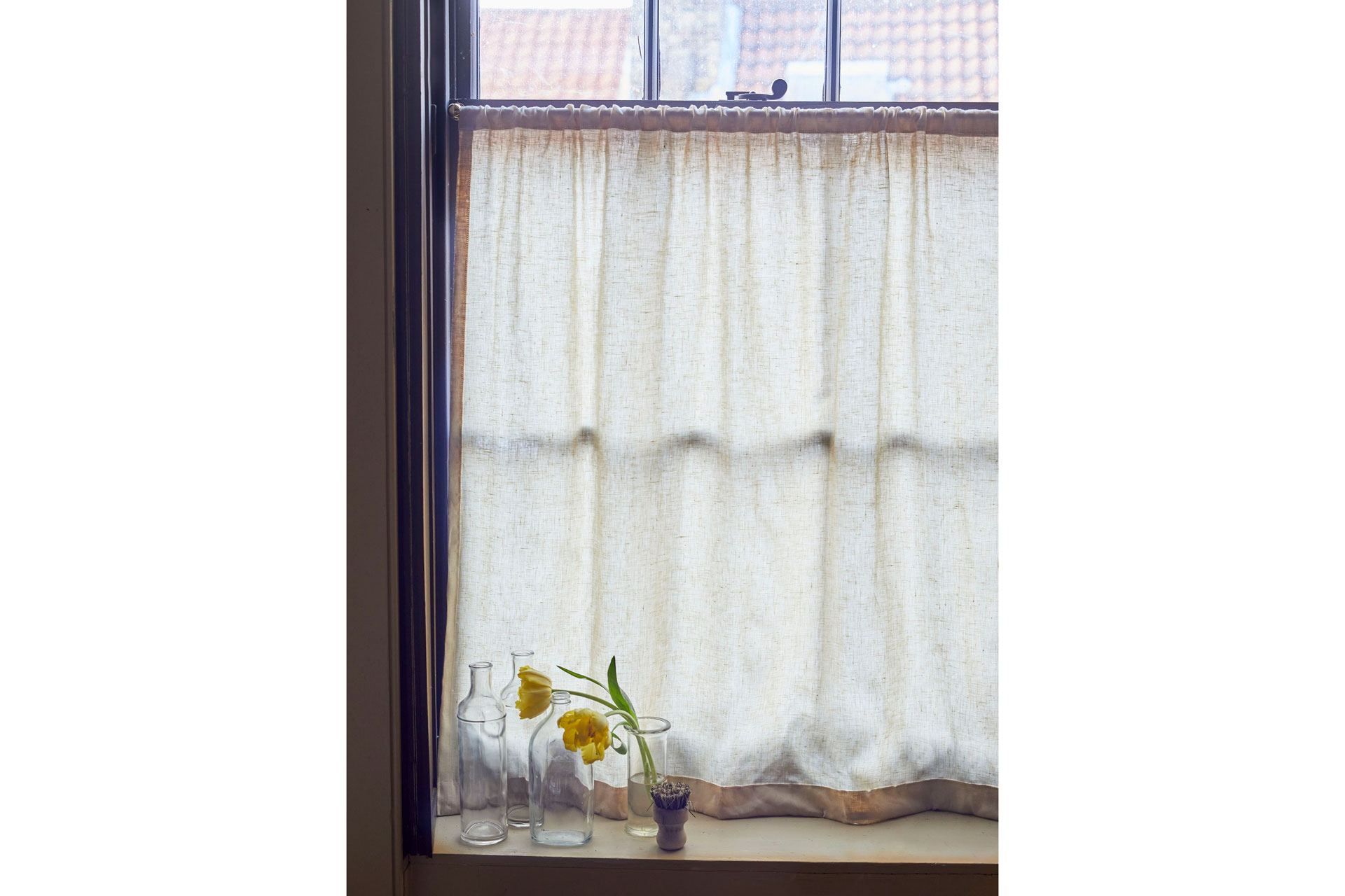 East London Cloth cafe curtain that's in a bathroom with a vase of flowers
