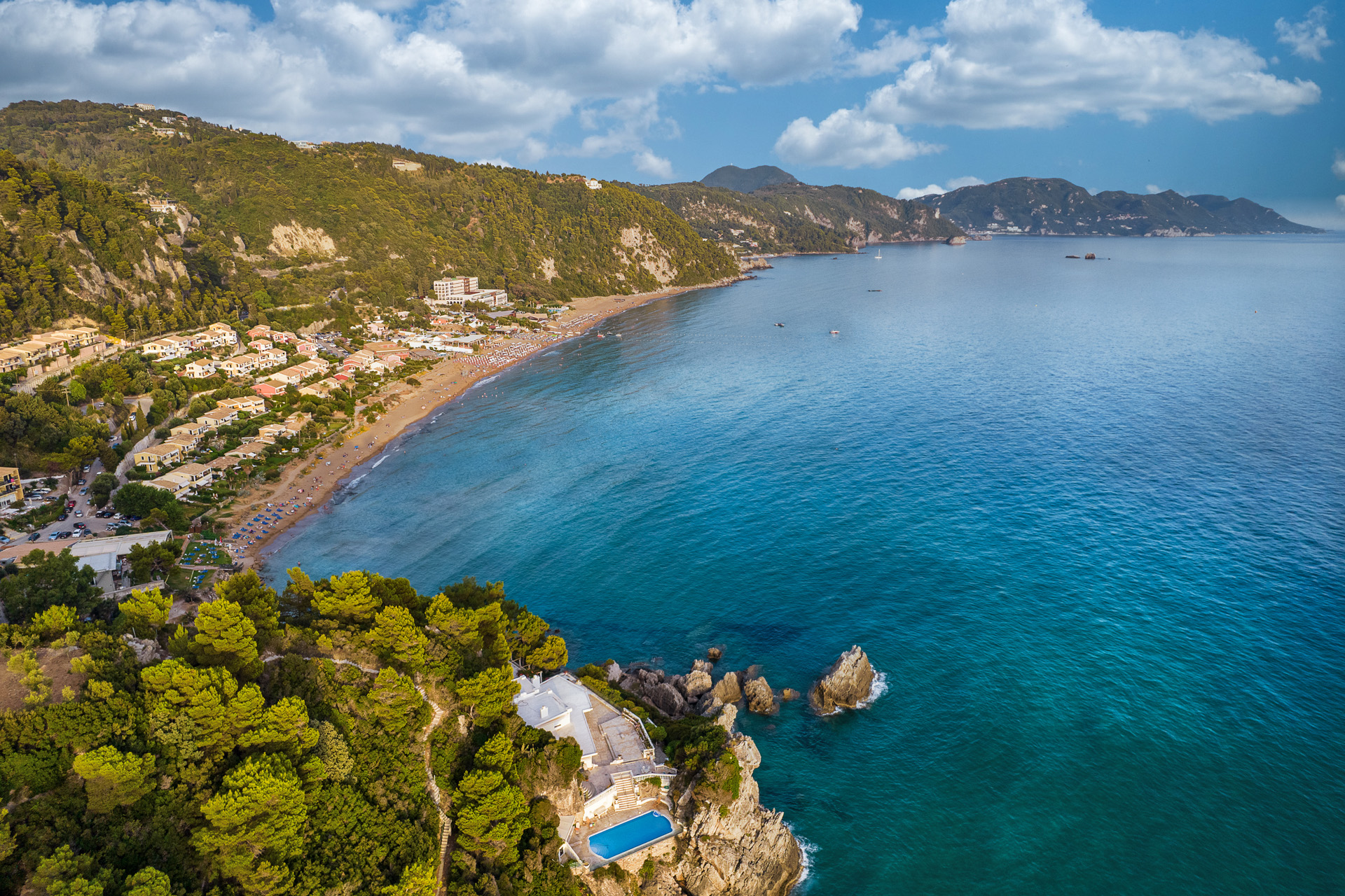 Aerial drone view over western coast and Glyfada beach at sunset. Island of Corfu, Greece.