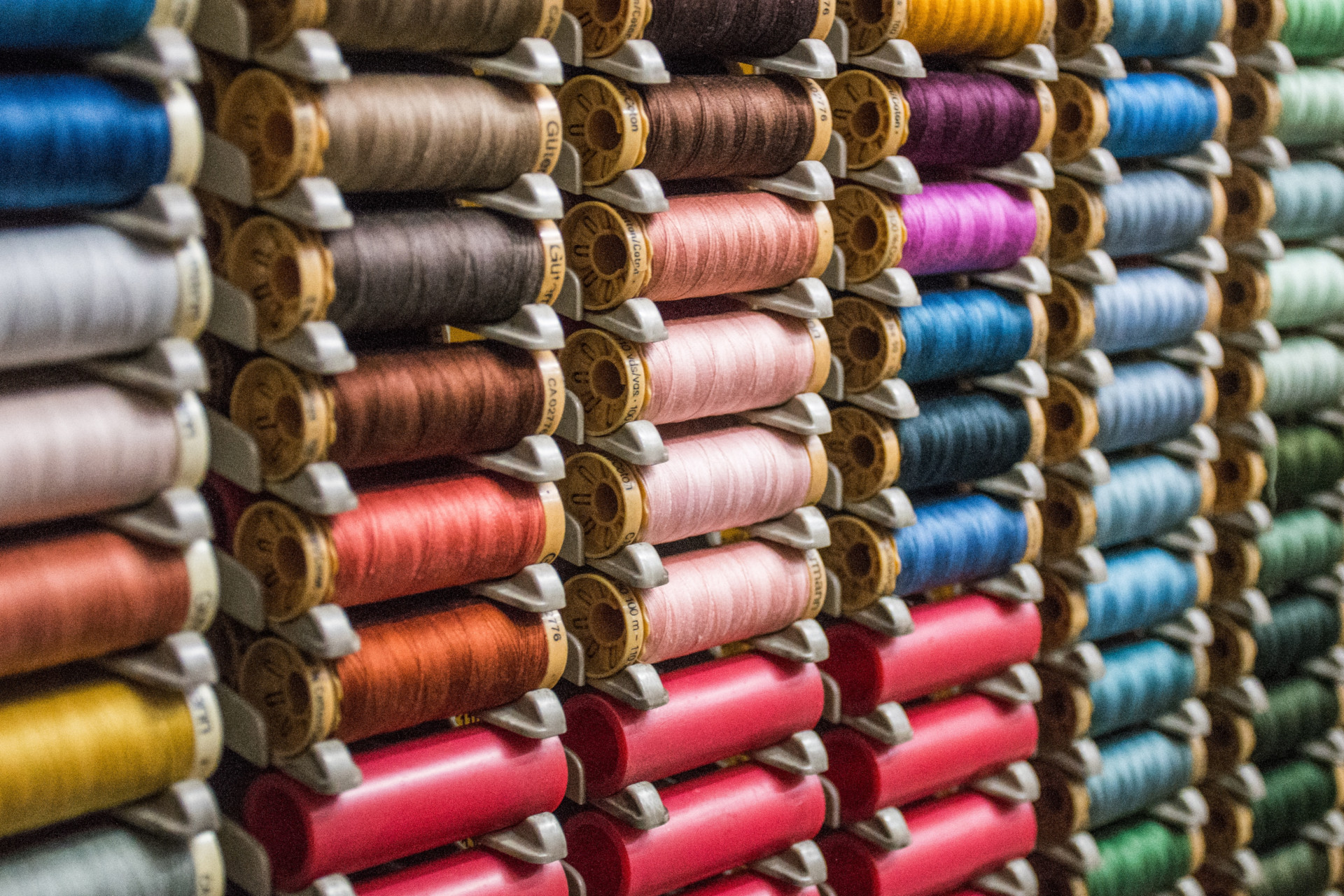Colourful spools of thread stacked up on shelves